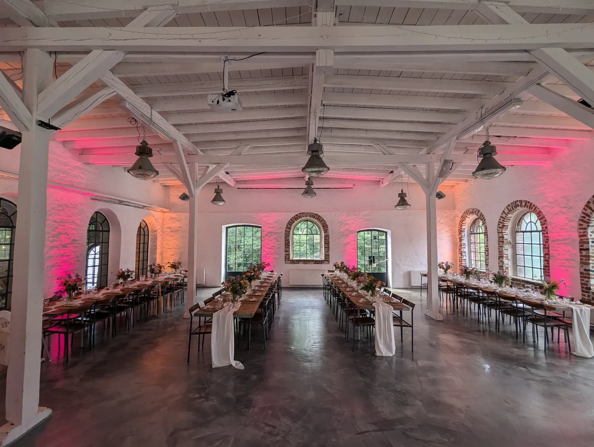 Festsaal mit gedeckten Tafeln in farbigem Licht